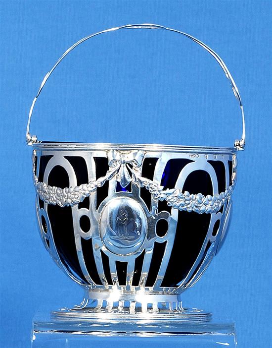 An Edwardian pierced silver sugar basket and blue glass liner, Height to handle 6”/155mm Dia 104mm Weight Silver only: 5.1oz/145grms